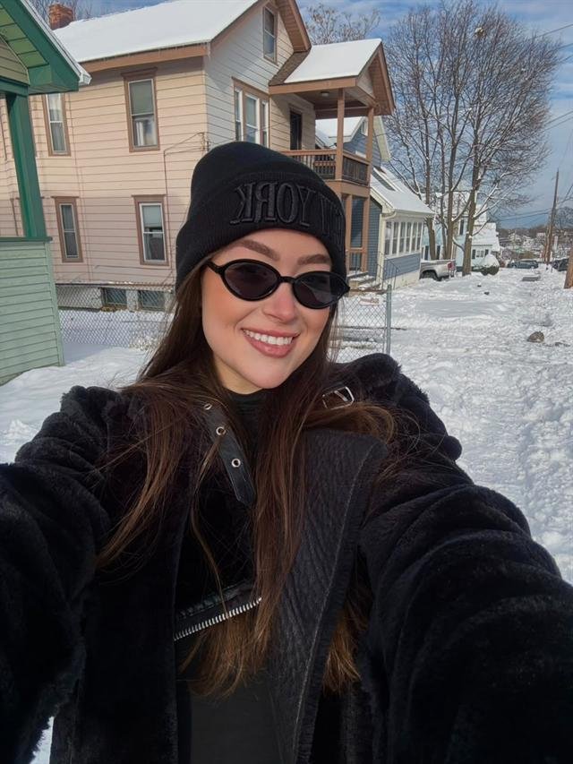 Sophia na neve, de gorro e óculos escuros