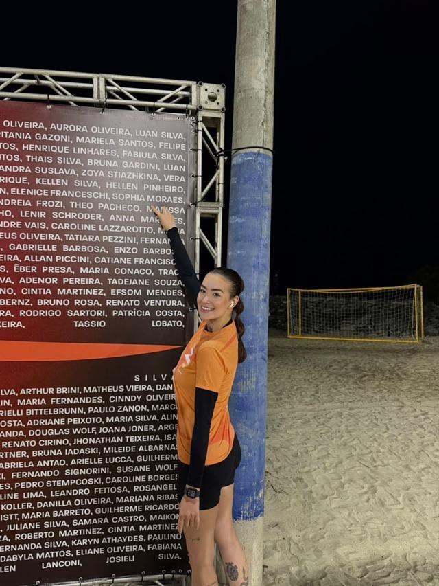 Sophia numa quadra de areia, à noite